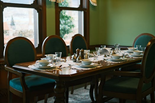 A beautifully set dining table with green accents, ready for a meal.