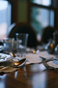 Close-up view of an elegantly set table in a restaurant, featuring silverware and dinnerware.