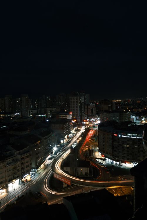 Free A vibrant urban cityscape with illuminated roads and buildings captured at night. Stock Photo