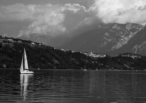 A sailboat on the lake with mountains in the background