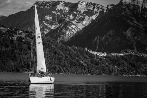 A sailboat is sailing on the water near mountains