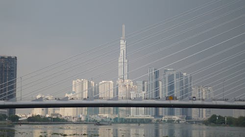 A bridge over a body of water with a city skyline in the background