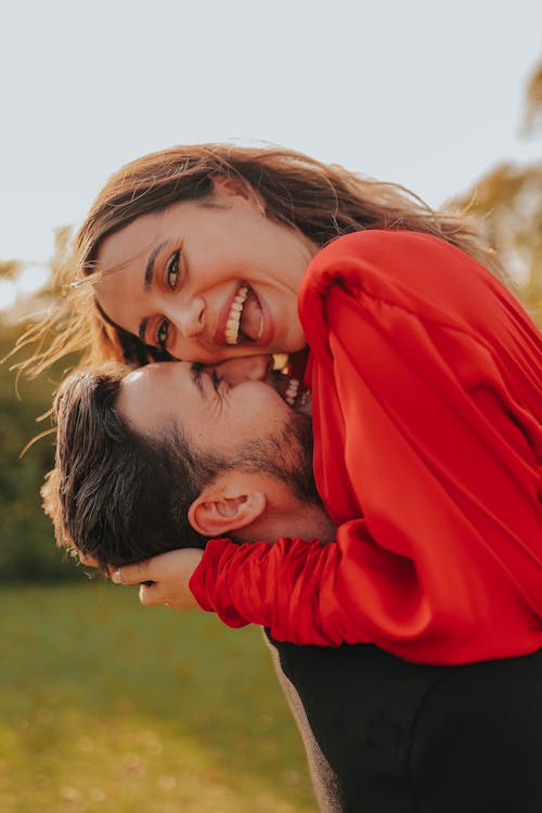 Man in Black Shirt Holding Woman in Red Sweater