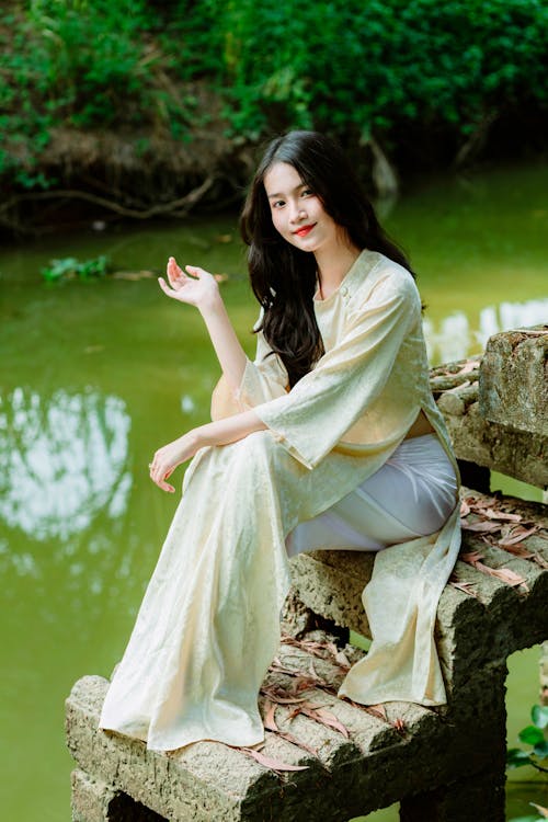 Portrait of a Beautiful Brunette Sitting on a Lakeshore Bench