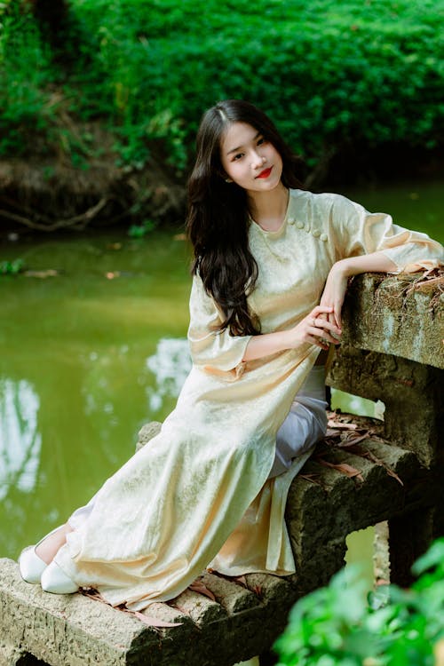 Portrait of a Long-Haired Brunette Sitting on a Stone Bench