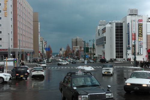 Free A busy winter street intersection in Otaru, Japan with cars and pedestrians on a cloudy day. Stock Photo