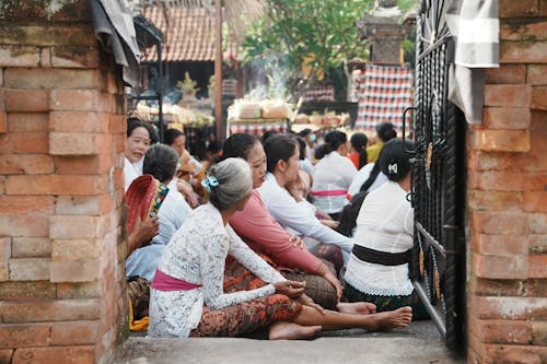 Free A group of people sitting on the ground in front of a temple Stock Photo