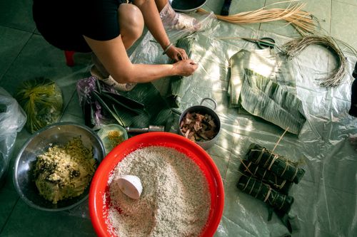 Free Woman preparing traditional Vietnamese banh tet with various ingredients. Stock Photo
