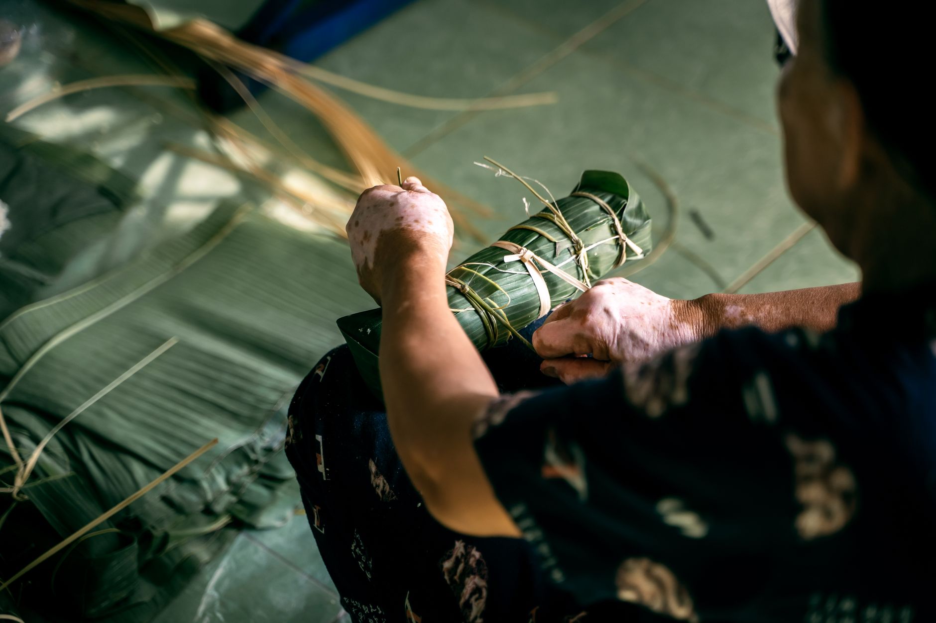 A close-up of a person crafting traditional Vietnamese banh tet, showcasing cultural craftsmanship.
