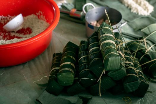 Vietnamese Banh Tet preparation with banana leaves and sticky rice ready for Lunar New Year.