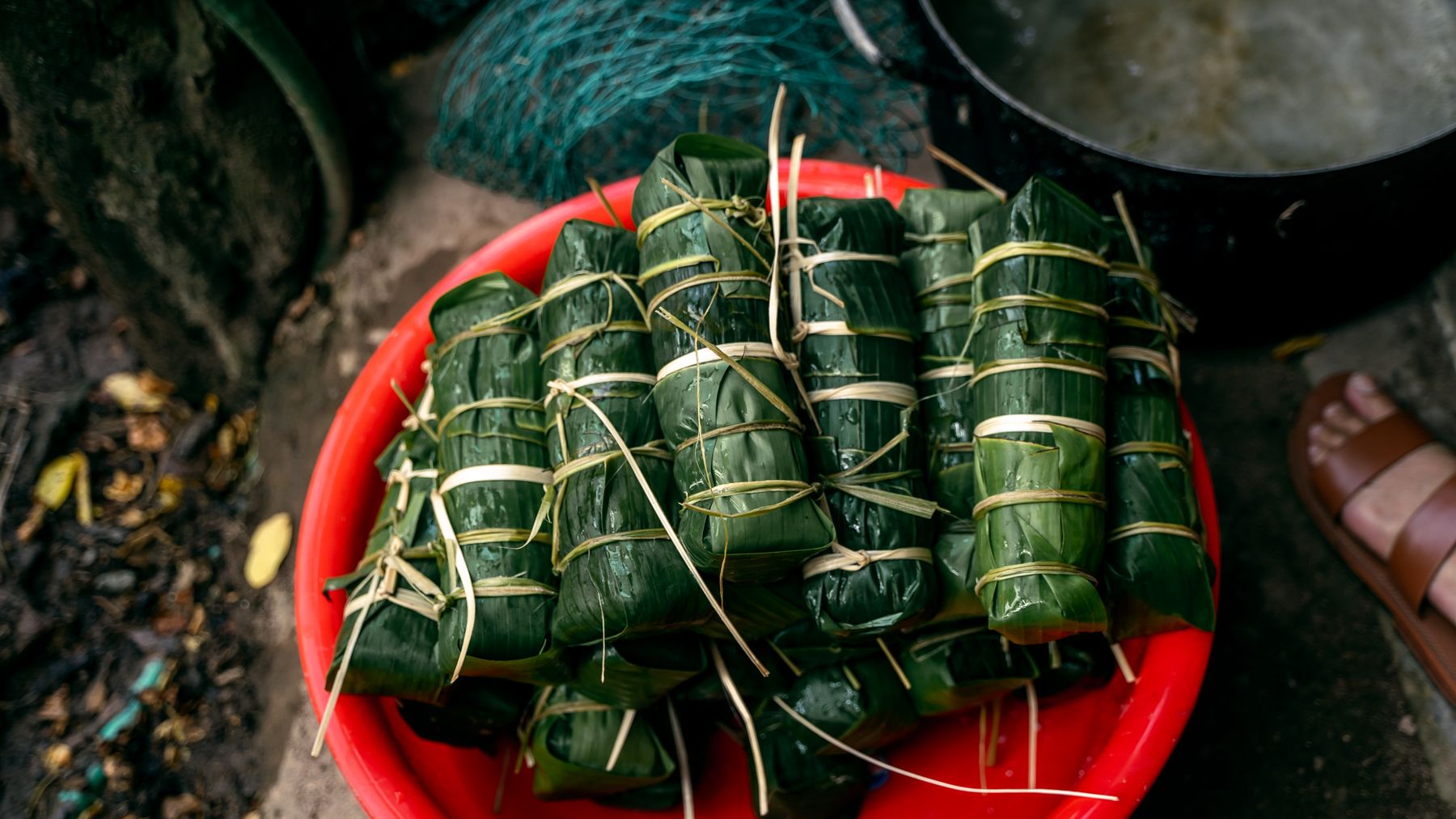 High-angle view of traditional Vietnamese Banh Tet wrapped in banana leaves, ready for cooking.