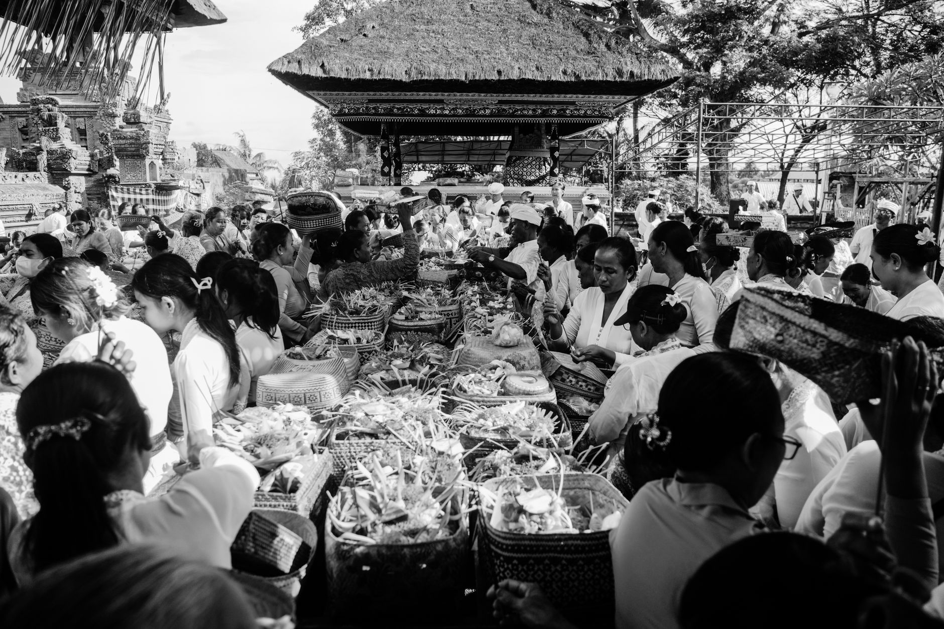 Black and white image of people participating in a traditional Balinese offering ceremony.