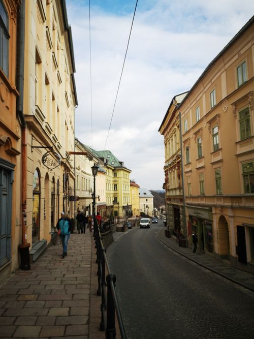 Free A picturesque European street lined with historic buildings under a blue sky, capturing urban elegance. Stock Photo