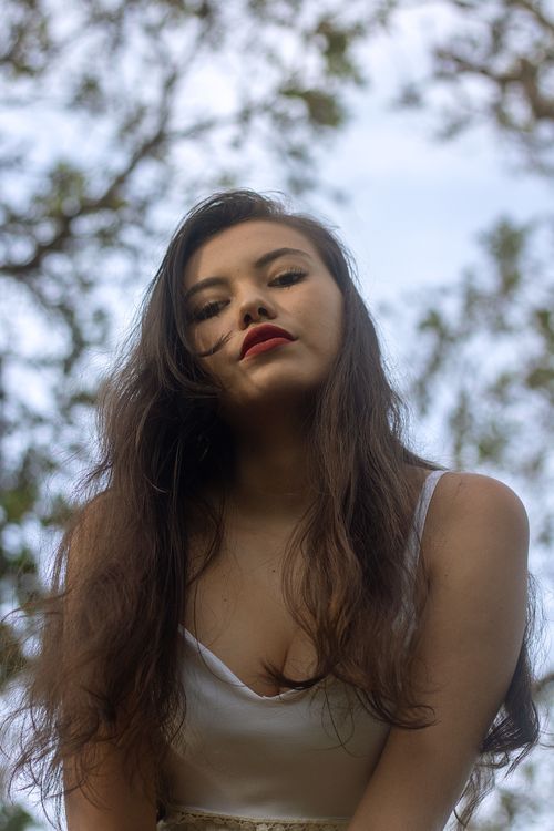 Free Close-up portrait of a young woman outdoors with flowing hair and bright lipstick. Stock Photo