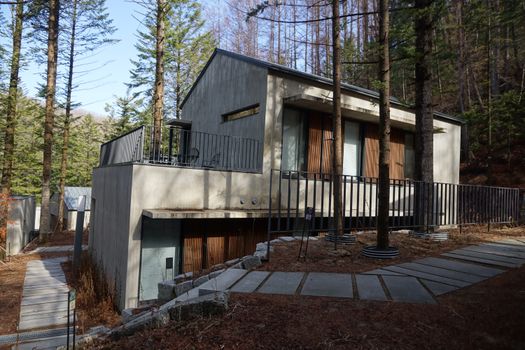 A modern house design set amidst a tranquil forest landscape in Pyeongchang, South Korea.