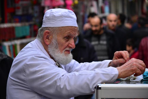 A man in a white hat is cutting something