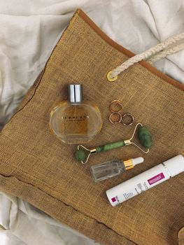 Aesthetic flat lay of beauty and skincare essentials on a rustic jute bag.