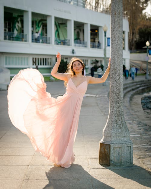 Woman in Pink Sundress Leaning on Lamppost