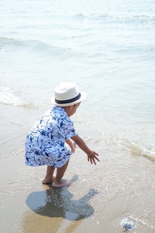Foto profissional grátis de areia, chapéu de sol, criança