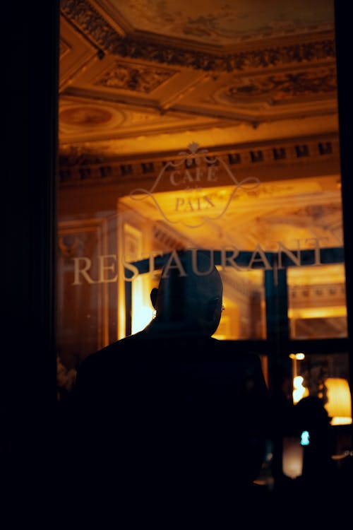 Silhouette of a Man Standing Inside a Restaurant 