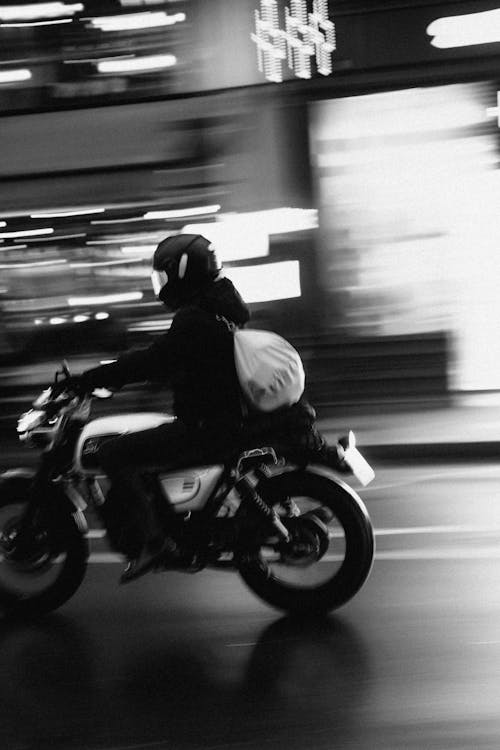 A Motorcyclist Riding on a Street in City 