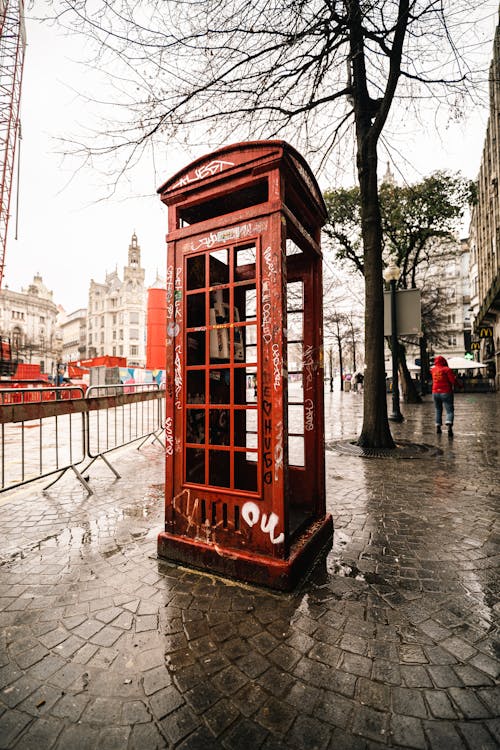 A red telephone booth on a rainy day