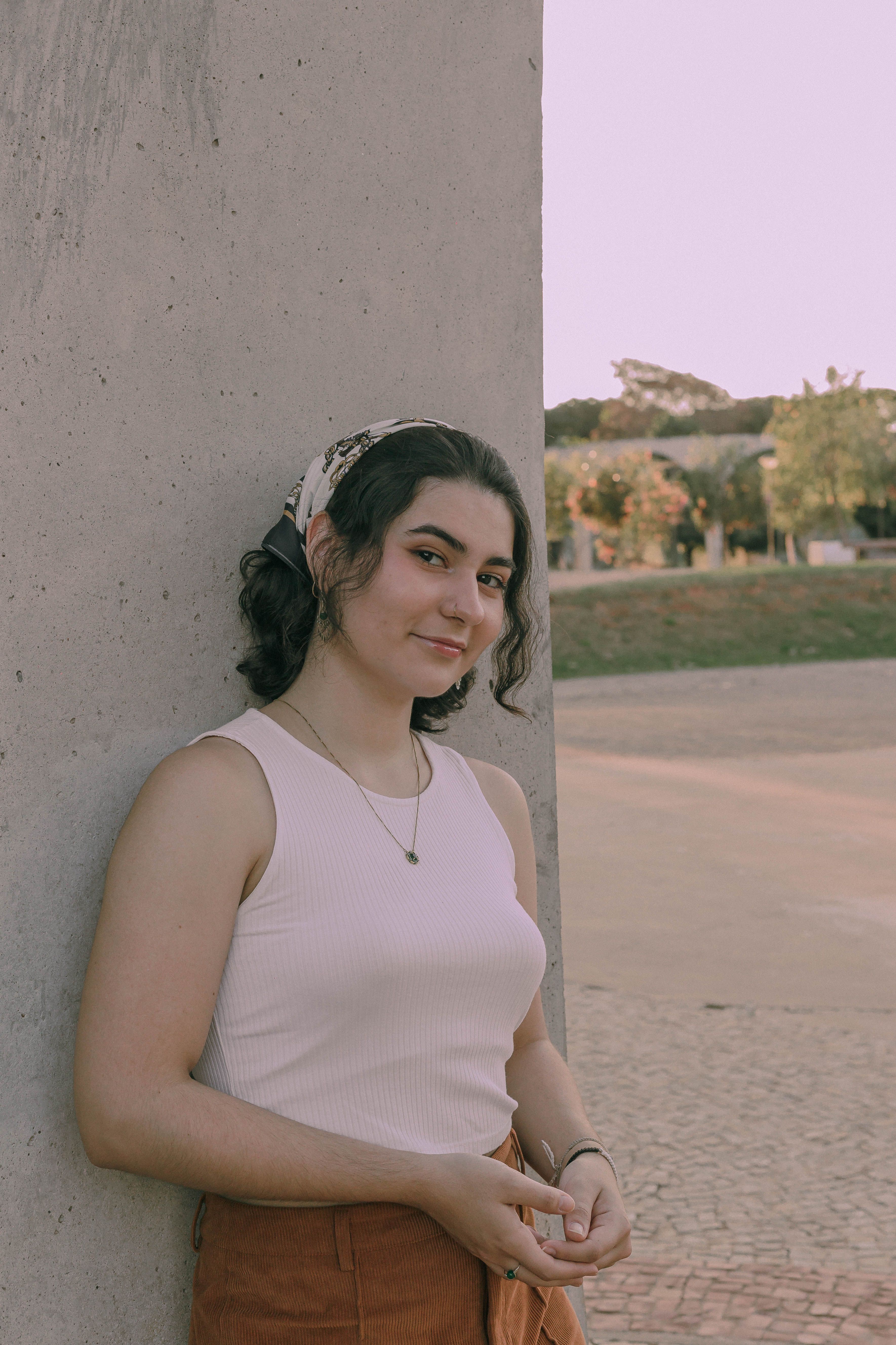Portrait of a young woman in a tank top leaning outdoors in Presidente Prudente.