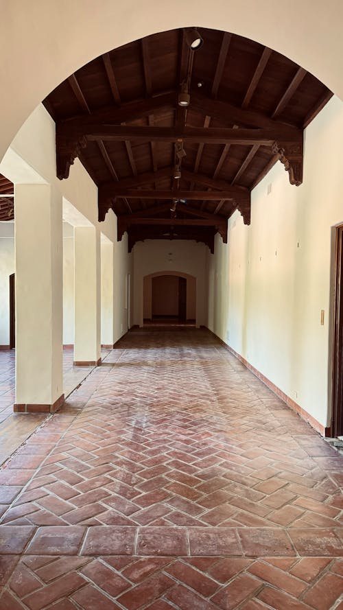 A long hallway with brick floors and arched ceilings