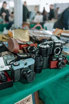 Close-up of vintage cameras on display at an indoor antique market stall.