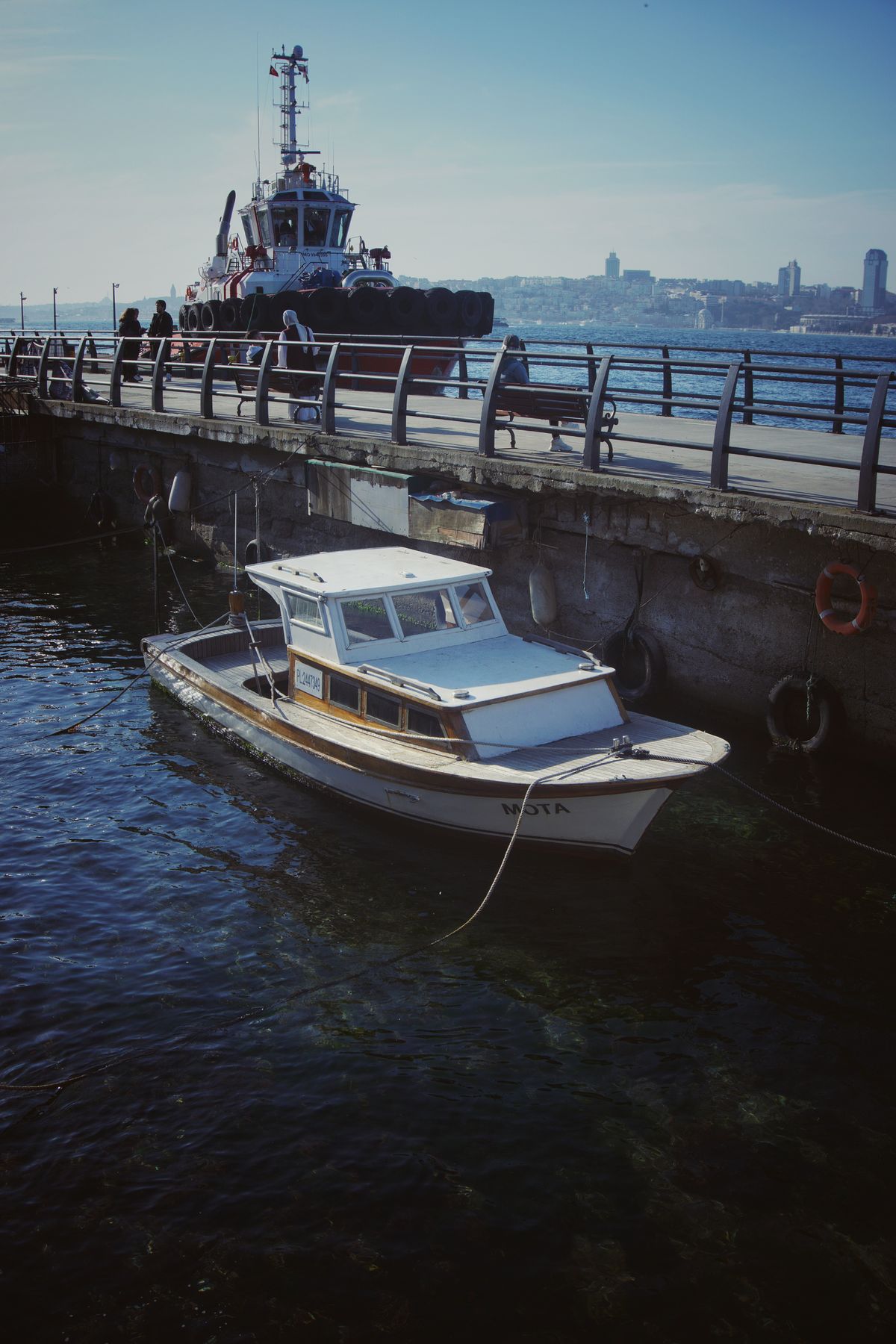 A serene harbor scene with a vessel moored at a pier