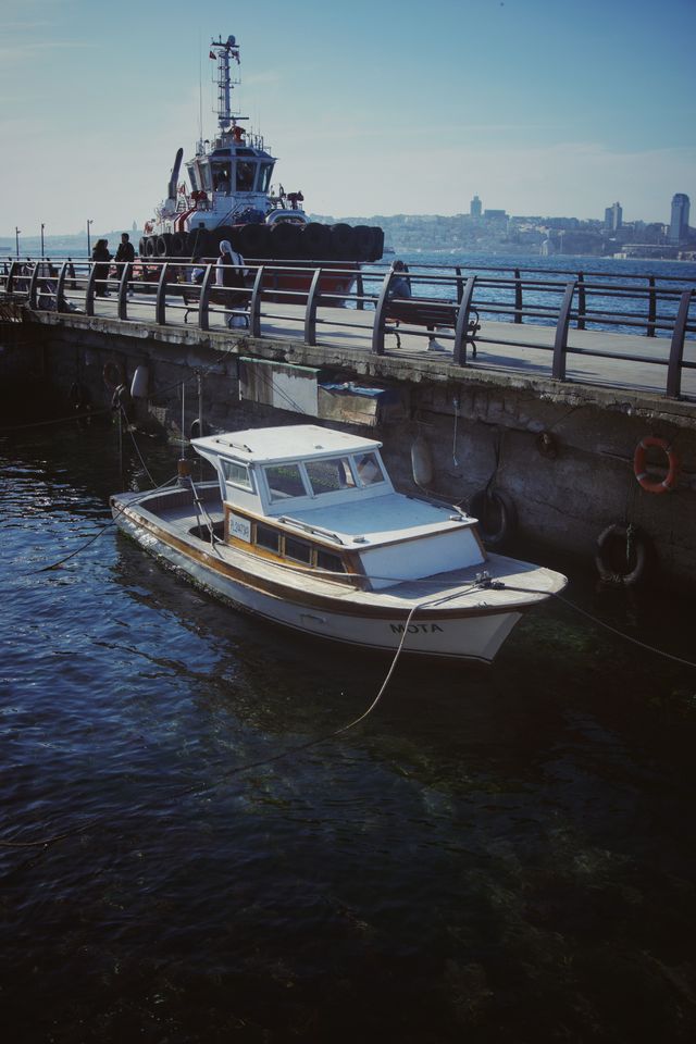 A serene harbor scene with a vessel moored at a pier