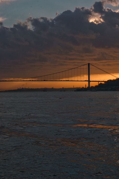 Free A stunning view of the Bosphorus Bridge silhouetted against a dramatic sunset sky in Istanbul, Turkey. Stock Photo