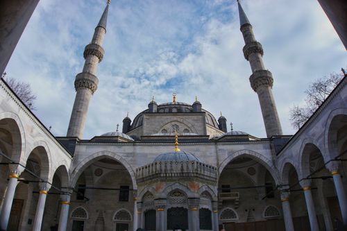 Free The intricate Ottoman architecture of Yeni Valide Mosque with its iconic minarets set against a clear blue sky. Stock Photo