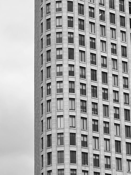 Free Black and white photo of a modern skyscraper showcasing urban architecture. Stock Photo