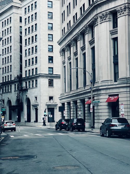 Free Urban street view featuring historic city architecture and cars during the day. Stock Photo