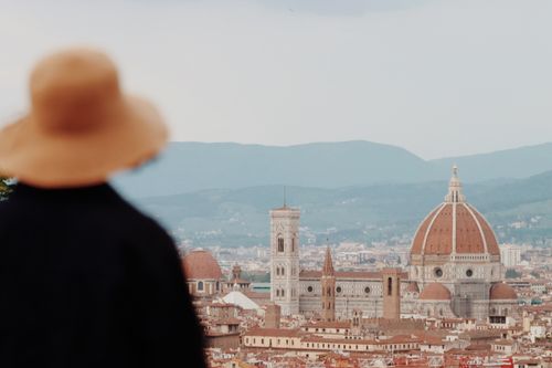 Free A woman in a hat views the iconic Florence skyline featuring the Duomo. Stock Photo