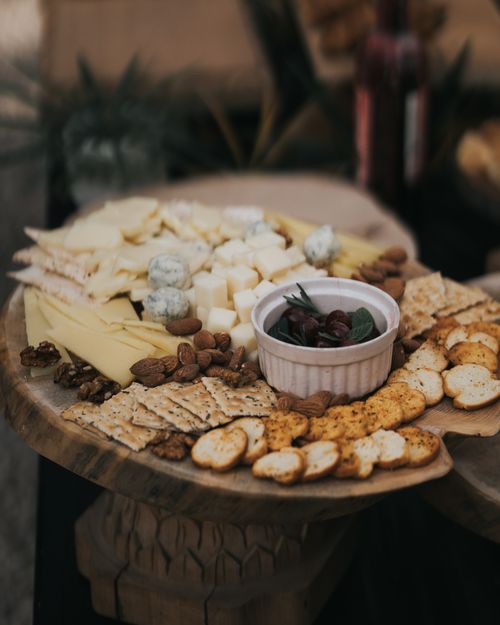 Free A delicious assortment of cheeses, nuts, and crackers on a rustic wooden board. Stock Photo