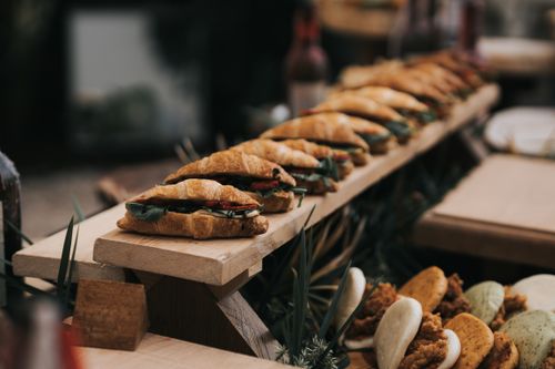 Free Appetizing croissant sandwiches arranged on a wooden board, captured at a cozy outdoor café in Antalya, Türkiye. Stock Photo