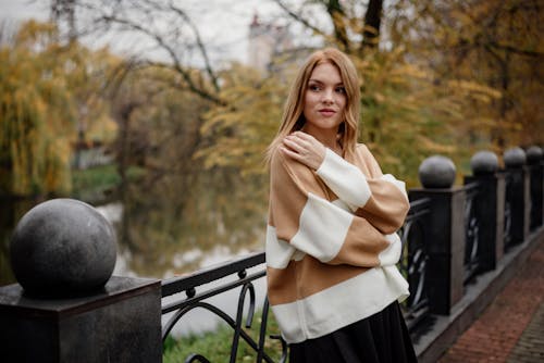 A woman in a sweater and skirt posing for a photo