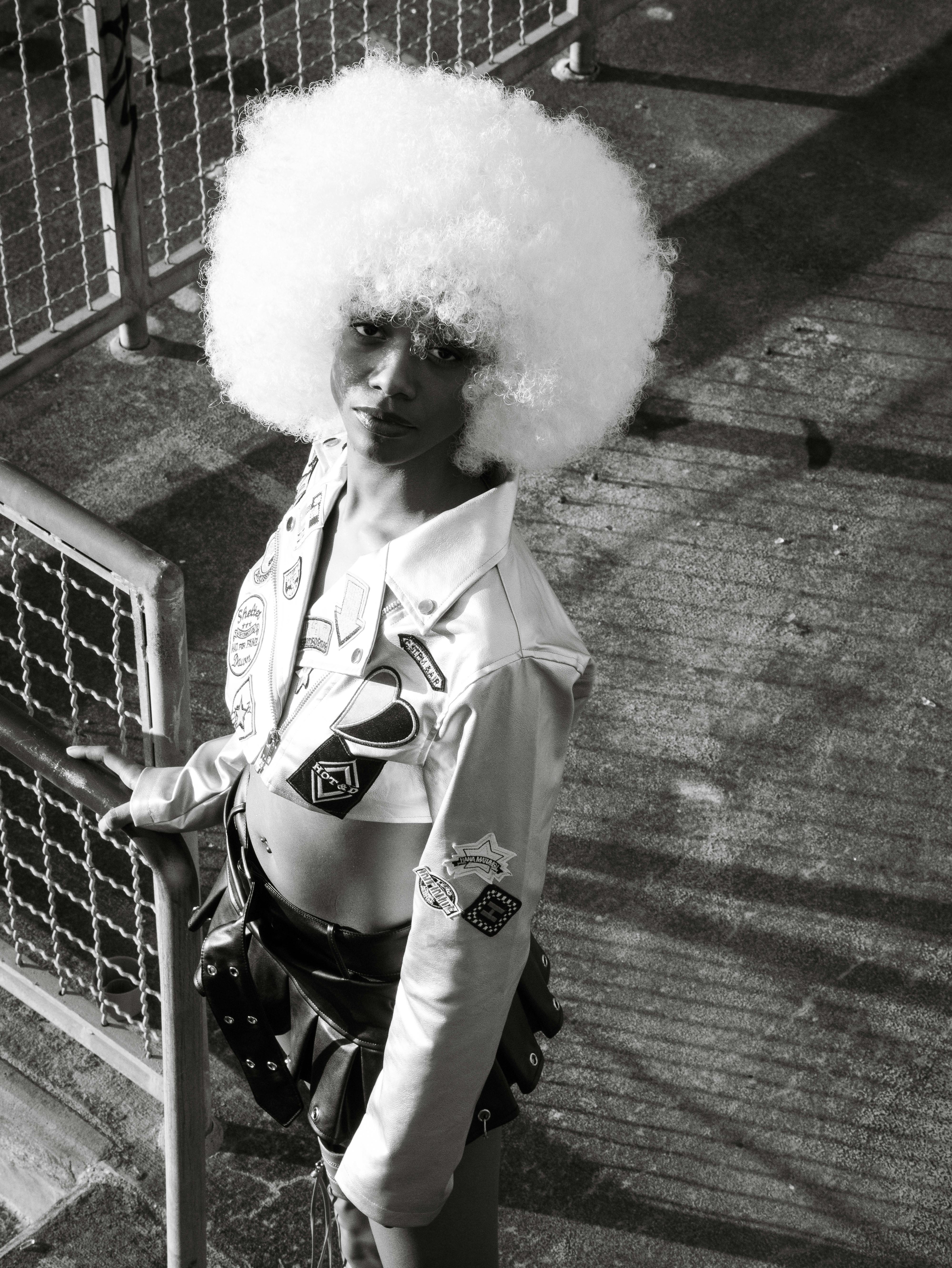 fashion model with big afro posing in a stadium