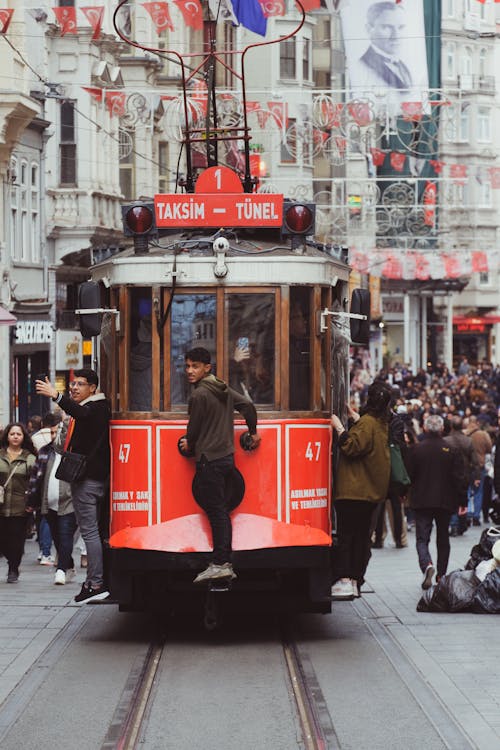 A red tram is traveling down a street