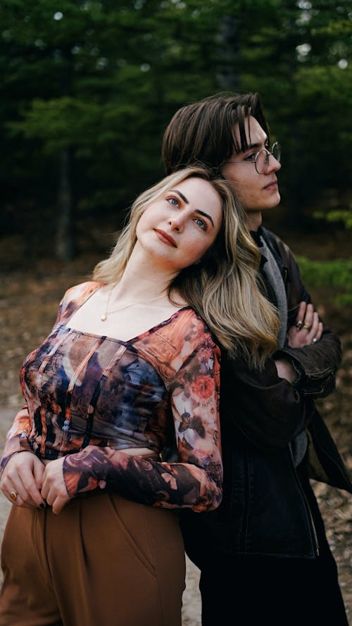 A young couple posing for a portrait in the woods