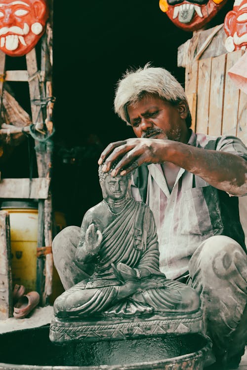 A man is working on a statue in a shop