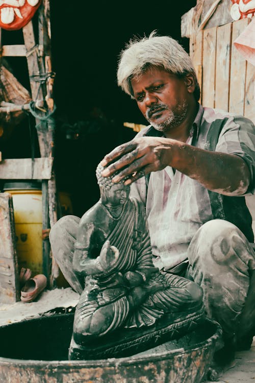 A man is working on a statue in a pottery