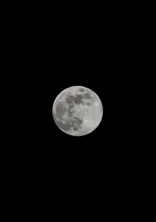 A full moon is shown in the dark