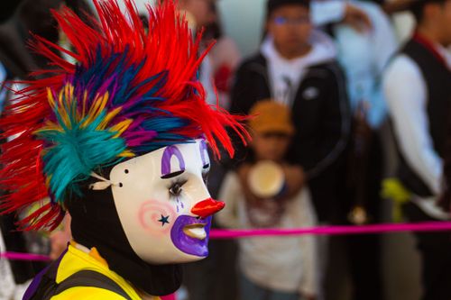 Free A vibrant clown with a colorful wig and mask at a Mexican carnival festival. Stock Photo
