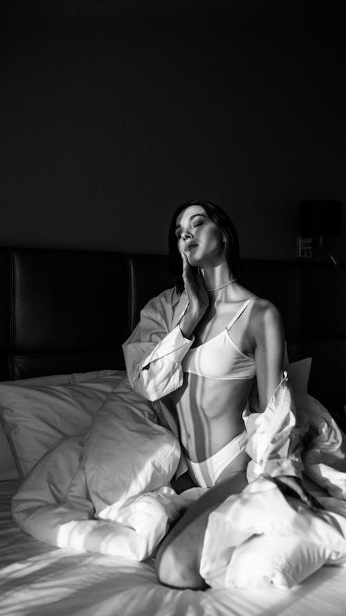 Black and White Photography of a Woman Posing in Bed
