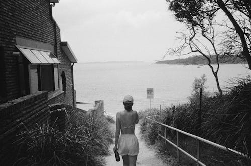 A woman walking down a path near the water