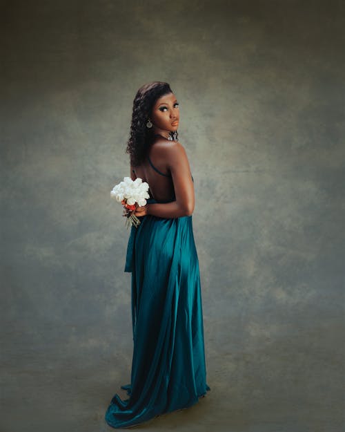 A beautiful woman in a blue gown holding flowers