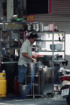 Street vendor preparing food at an urban stall, showcasing authentic street food culture.